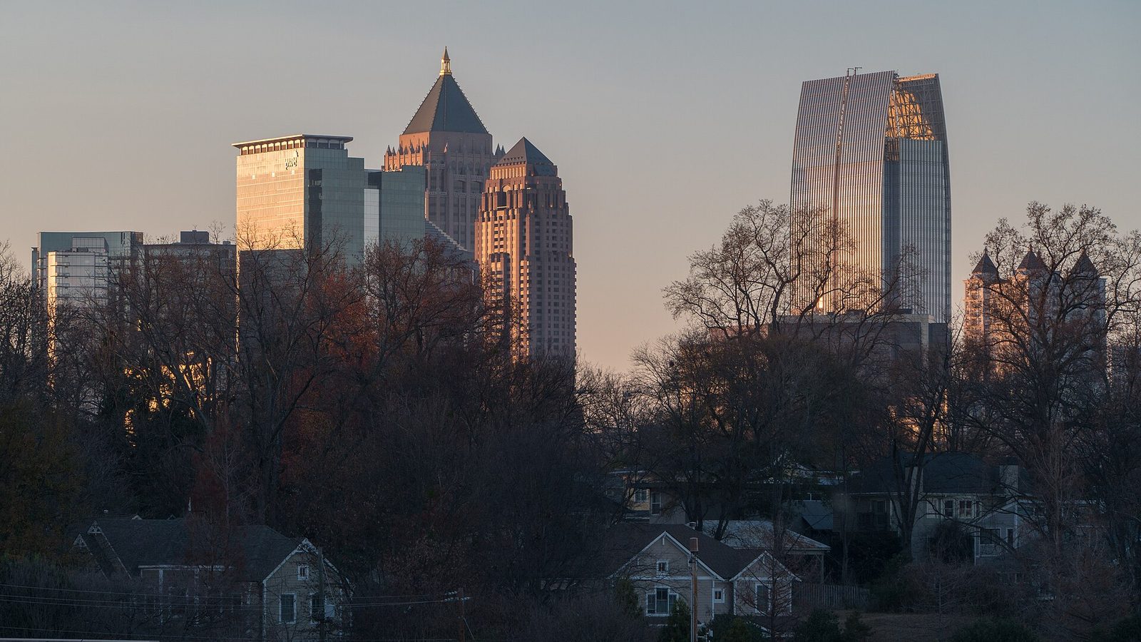 Midtown Atlanta skyline at sunset above neighborhood rooftops